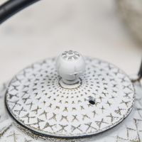 Close Up Of Gold & White Cast Iron Teapot Lid Close Up Of Gold & White Cast Iron Teapot Lid