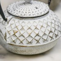 Close Up Of Gold & White Cast Iron Teapot Finish Close Up Of Gold & White Cast Iron Teapot Finish