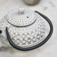 Close Up Of Gold & White Cast Iron Teapot Top Close Up Of Gold & White Cast Iron Teapot Top