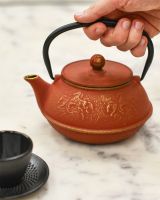 Cast Iron Sunset Orange and Gold Horse Design Teapot In Use Cast Iron Sunset Orange and Gold Horse Design Teapot In Use