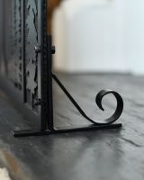 Close up of ornate base detail on black fire guard