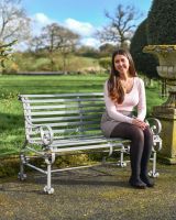 Grey Two Seater Park Bench With woman Sat on it 