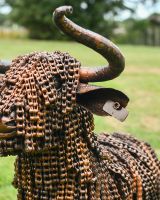 Close up of intricate horn and tagged ear detailing on recycled metal highland cow garden sculpture Close up of intricate horn and tagged ear detailing on recycled metal highland cow garden sculpture