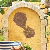 Floating House on Balloons Steel Wall Art on a Yellow Wall