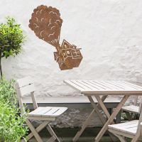 Floating House on Balloons Steel Wall Art above a Wooden Table set