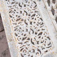 Close up of ornate design on Antique Cream Cast Iron Bench Close up of ornate design on Antique Cream Cast Iron Bench