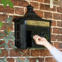Man using key to open post box door
