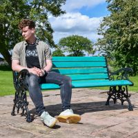 Male sat on Green Victorian Park Bench for scale