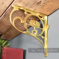 Polished Brass "Lotus Flower" Shelf Bracket Holding up a Wooden Shelf Polished Brass "Lotus Flower" Shelf Bracket Holding up a Wooden Shelf