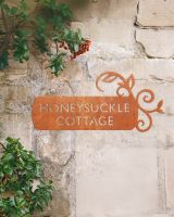 "Lovestone" Corten Steel House Name Sign on a Rustic Wall
