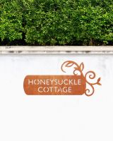 Corten Steel House Name Sign in situ on a White Garden Wall
