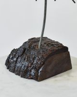 Close up of freestanding wood base on recycled metal art sculpture