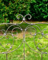 Close up of intricate backrest detail on wrought iron garden bench