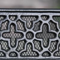 Close up of mesh netting and cast iron "flower pattern" air brick