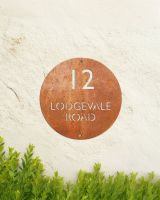 Modern Circular Corten Steel House Sign in Situ on the Front of a House Modern Circular Corten Steel House Sign in Situ on the Front of a House