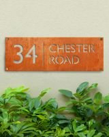 Corten Steel House Number Sign in Situ on a Modern Green Wall