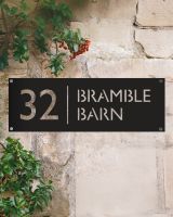 Modern Rectangular Steel House Number Sign on a Rustic Sandstone Wall 