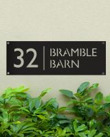 Black Rectangular Steel House Number Sign Mounted onto a Green Painted Wall 