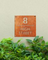 Modern Square Corten Steel House Number Sign in Situ Outdoors on a Green Wall