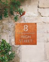 Modern Square Corten Steel House Number Sign on a Rustic Wall