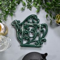 Green Cast Iron Kettle Trivet on Blue Table Green Cast Iron Kettle Trivet on Blue Table