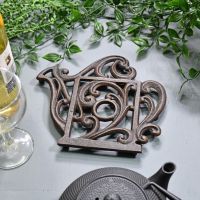 Rustic Kettle Shaped Cast Iron Trivet in Situ on Blue Table Rustic Kettle Shaped Cast Iron Trivet in Situ on Blue Table