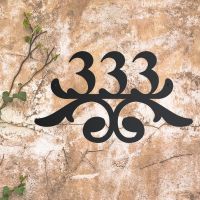Traditional Iron Ornate Number Sign on a Rustic Wall Traditional Iron Ornate Number Sign on a Rustic Wall