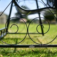 Ornate scroll decorative ironwork on swing bench