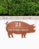 Pig Corten Steel House Name Sign on a White Garden Wall Pig Corten Steel House Name Sign on a White Garden Wall