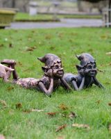 "Reverie" the Pixie Cast Aluminium Garden Sculpture in Verdigris lying next to copper version