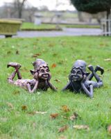 "Reverie" the Pixie Cast Aluminium Garden Sculpture in Verdigris lying next to copper version in parallel