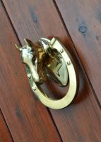 Horse door knocker on wood door