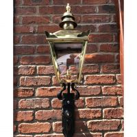 View of the Front of the Polished Brass Harrogate Wall Lantern on Bracket on a Brick Wall