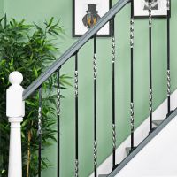 "Rabanne" Stainless Steel Stair Spindle in Use by a Green Wall "Rabanne" Stainless Steel Stair Spindle in Use by a Green Wall