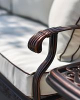 Close up of ornate armrests with rolled detailing.