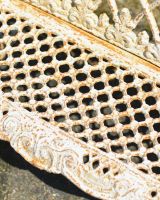 Close up of intricate seat detailing on cast iron bench