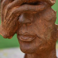 Close-up of the Detail on the Rustic Cast Iron Abstract Face Sculpture