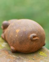 Close-Up if Pig Tail on Rustic Cast Iron Rounded Lying Pig Garden Sculpture Close-Up if Pig Tail on Rustic Cast Iron Rounded Lying Pig Garden Sculpture