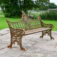 Side view of rustic cast iron three seater gothic bench 