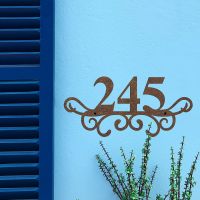 Traditional Iron Ornate Number Sign on a Blue Wall Traditional Iron Ornate Number Sign on a Blue Wall