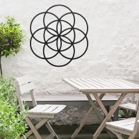 Black "Seed of Life" Steel Wall Art in Situ Outdoors by a Wooden Table and Chairs Set