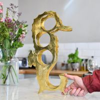 Close up of "Seahorse" Wine Rack with hand for scale 