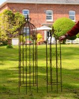 Scale view of rustic finish ornate steel garden obelisks
