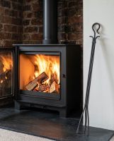 The Long Iron Fireside Tongs Displayed in Front of a Traditional Log Burner in a Country Home - Digital Illustration The Long Iron Fireside Tongs Displayed in Front of a Traditional Log Burner in a Country Home - Digital Illustration