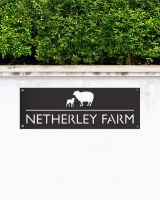 Black Sheep & Lamb Steel House Name Sign Mounted onto a White Garden Wall