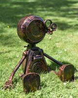 Sitting Robot Recycled Metal Sculpture in grass