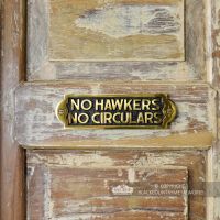 "No Hawkers No Circulars" Sign in Situ on a Rustic Wooden Surface