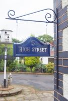 Blue Arched Hanging House sign on bracket attached to wall