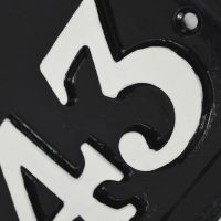 Close up of hand painted house numbers and screw holes