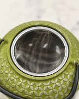 Close up of Metal Tea Infuser In Cast Iron Teapot 